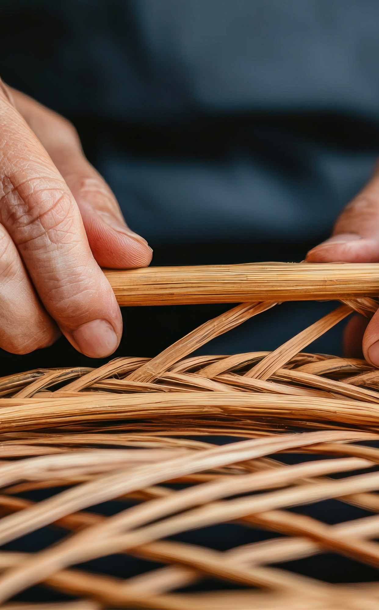 Craftsman hand weaving bamboo basket, showcasing traditional bamboo craftsmanship